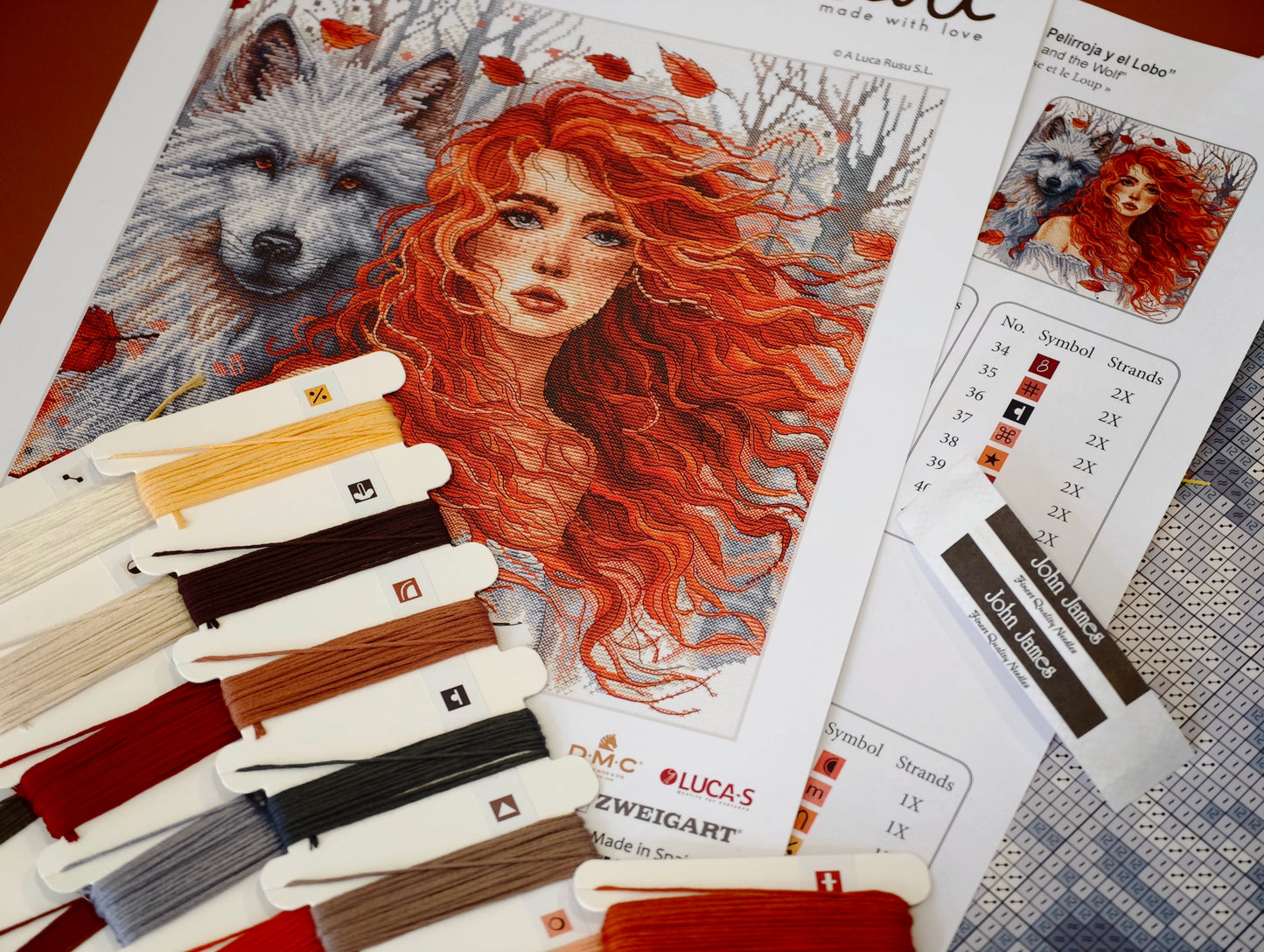 Dettaglio del kit ricamo AVA P049 – La ragazza dai capelli rossi e il lupo